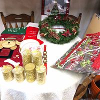 Wide shot showing entire table with candles, wreath, stockings, plate, jingle bells, and portion of lighted mirror