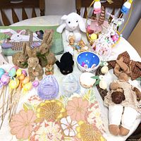 Full view of the Easter decor collection items arranged on a table showing placemats, bunnies, eggs, basket, and figurines.