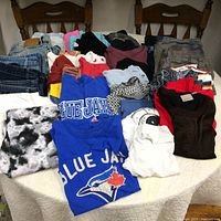 Overview of the assorted clothing laid out on a table showing pants, shirts, shorts with a variety of colors and styles.