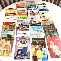Full collection of approximately 100 vintage knitting pattern books and magazines laid out in rows showing the colorful covers with models in knitwear and assorted titles.