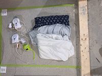 Full lot arranged on floor, showing mattress covers, baby monitors, and reusable bag