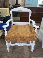 Front view photo of white painted wooden chair featuring open back design and thick textured cushion seat.