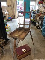 Wooden folding travel easel with tray inside a garage/workshop setting