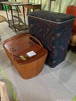 Photo of the laundry hamper next to the wooden picnic basket on the floor showing overall appearance and size comparison.