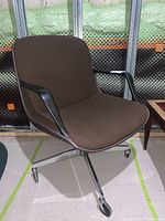 Front and side view of the mid-century modern office chair showing brown plastic seat and chrome base with casters.