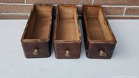 Photo showing the three wooden drawers from front showing knobs and general condition.
