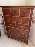 Front view of wooden highboy showing drawer configuration and finish