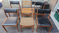 Overview of six chairs arranged outdoors on pavement.