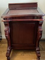 Front view showing carved legs and panel side