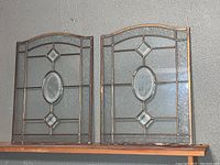Pair of stained glass wall hangings side by side showing overall design and condition.