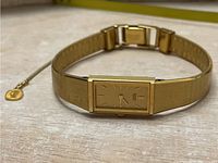 Front view of Seiko gold coloured rectangular watch including dial and metal band