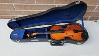 Full view of child's violin in open Skylark case with blue felt lining.