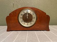 Front view of the Stratford mantel clock with wooden casing and circular dial.