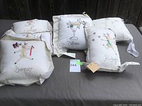 Five Christmas-themed pillows including reindeer characters named Donner, Blitzen, Rudolph, and a snowman design laid out together.