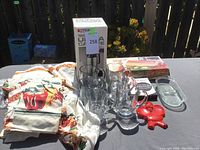 Entire lot showing carafe box, Dazey Seal-A-Meal, beer mugs, baking dish, and kitchen curtains with bell pepper design