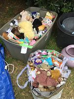 Photo showing tubs and bags filled with assorted plush toys including Beanie Babies, some loose and some packed.