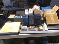 Wide view of the table showing boxes of materials including books and cards, with Recorded Books and textbooks arranged in front.