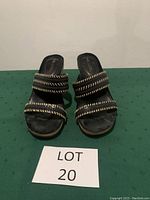 Front view of the pair of black Aerosoles sandals showing three straps with gold stitching detail and slight wear on footbed.