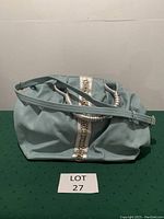 Front and top view of blue tote bag showing silver detailing and removable shoulder strap.