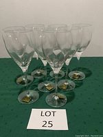 Full view of all 8 Dansk crystal wine glasses arranged in rows on a green cloth background showing the spiral design and stems.