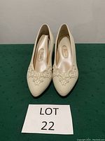 Front view of the white Dyeables pumps with pearl and lace details on pointed toes, size 7.5.