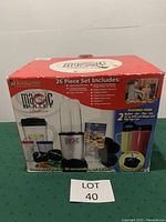 Front view of unopened Magic Bullet Deluxe 26-piece blender set box showing contents and branding.