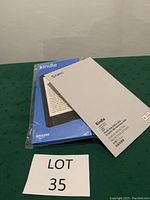 Blue sealed 10th generation Amazon Kindle box with white Nupro protective screen packaging on top.