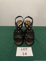Front view of black Madden Girl wedge sandals, showing strappy design and floral insole.