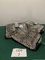 Four leopard print makeup bags displayed with LOT 7 sign, showing exterior design and condition never used.