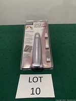 Front view of the packaged Revlon StyleSpa Personal manicure system showing the silver device and four attachments in clear plastic packaging.