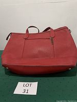 Front view of the red leather Wilson tote bag showing shape, color, and handles.