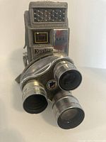 Front view of Keystone KA-1 camera showing three rotating lenses and Electric Eye viewfinder.