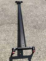 Full length view of the 50-inch black aluminum camera slider rail on concrete surface