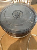 Overview of the food dehydrator showing stacked trays and top lid with handle.
