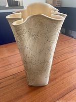 View front of beige wavy rim glass vase with a textured cracked pattern.