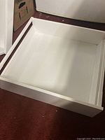 White Ikea Maximeria medium drawer with front panel, empty and shown upright.