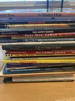 Stack of 18 children's books showing spines with titles and authors.