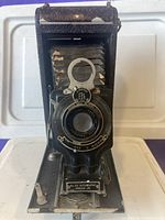 Front view of Kodak No. 2-C Autographic Junior camera showing lens, bellows, and folding plate with maker's label.
