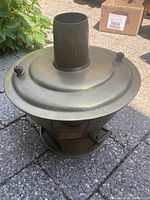 Photo showing front view of brass Mongolian hot pot with lid and chimney