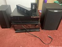 Stereo equipment including two Samsung receivers, Polk Audio subwoofer, Samsung subwoofer, small Samsung speakers, and passive sound bar.