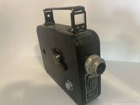 Photo showing right side and top foldable handle of the black Cine-Kodak Eight Model 25 8mm film camera.