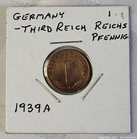 Front side of 1939 German Third Reich 1 Reichspfennig coin showing numeric denomination and wreath inside protective holder.