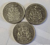 Three Canadian 50 cent coins dated 1999 showing the full lot.