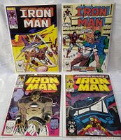 Lot of 4 vintage Marvel Iron Man comic books displayed upright with covers visible.