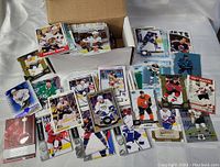 Box containing a large amount of hockey cards spread out showing various players and card designs.