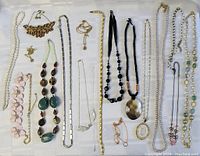 Full view of all necklaces laid out, showing a variety of materials including beads, chains, pearls, and fabric ribbons in assorted colors and styles.