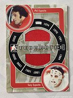 Photo of the front of the hockey card showing both red jersey swatches and photos of Phil and Tony Esposito.