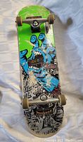 Full view of the Santa Cruz skateboard showing artwork and mounted components.