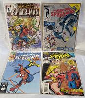 Four Spider-Man comic books displayed face up in protective sleeves. Colors are vibrant, showing detailed cover art of main characters.