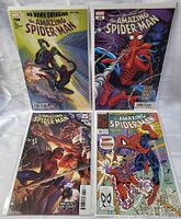Four The Amazing Spider-Man Marvel comic books in plastic sleeves, colorful illustrated covers, different issues visible